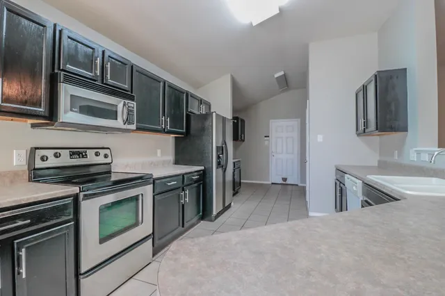 a kitchen with stainless steel appliances granite countertop a stove and a sink