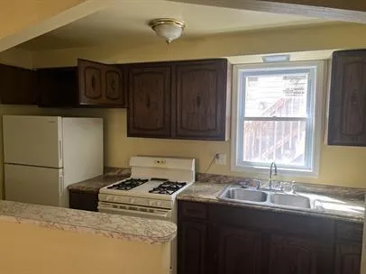 a kitchen with granite countertop a sink stove and cabinets