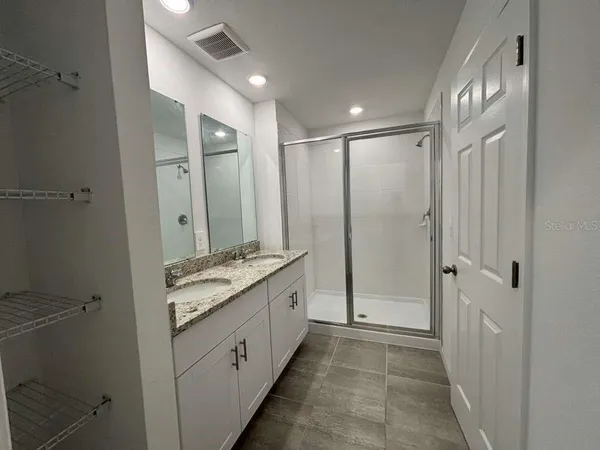 a bathroom with a granite countertop sink a mirror and a bathtub