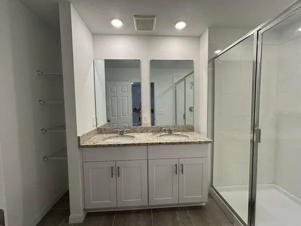 a bathroom with a granite countertop sink and a mirror