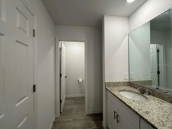 a bathroom with a granite countertop sink and a mirror