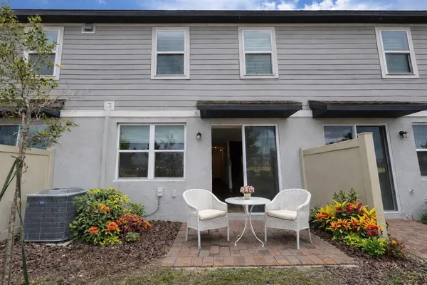 a view of a house with chairs and table in a patio