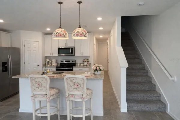 a kitchen with stainless steel appliances granite countertop a microwave a stove and a wooden floors