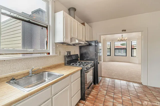 an empty room with windows and chandelier