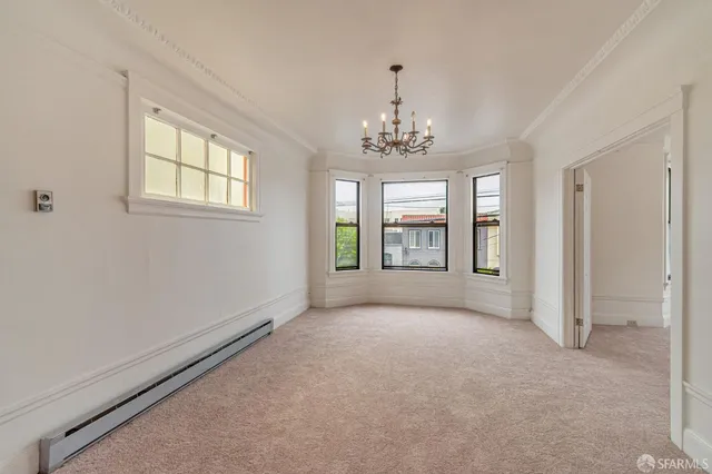 wooden floor in an empty room with a chandelier