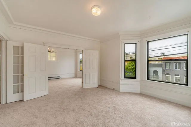 a view of an empty room with a window and a bathroom