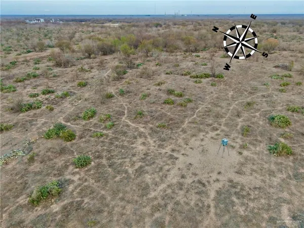 a view of a dry yard with wooden fence
