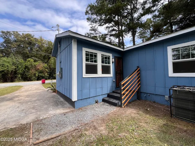 a backyard of a house with barbeque oven and wooden fence