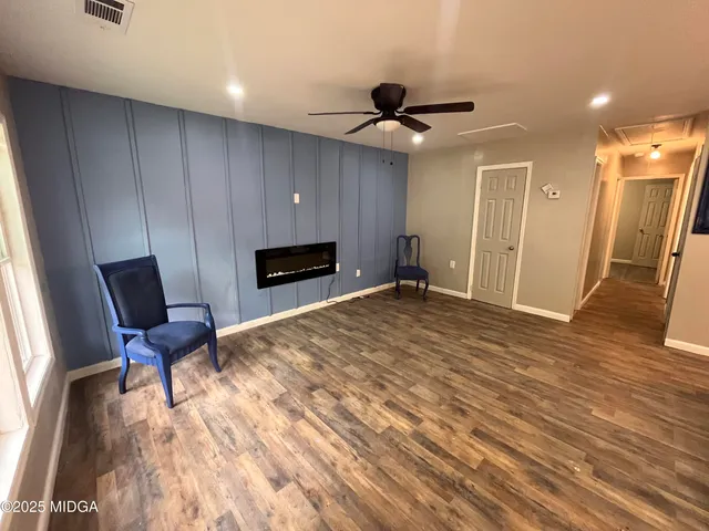 a furnished livingroom with a hardwood and a ceiling fan