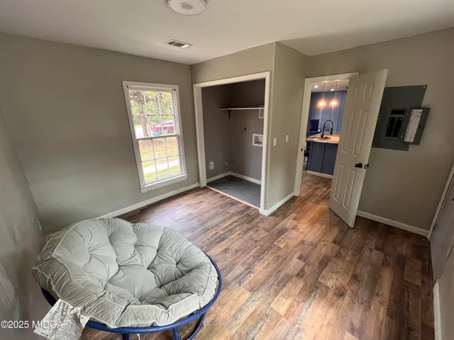 a view of a livingroom with wooden floor and a window
