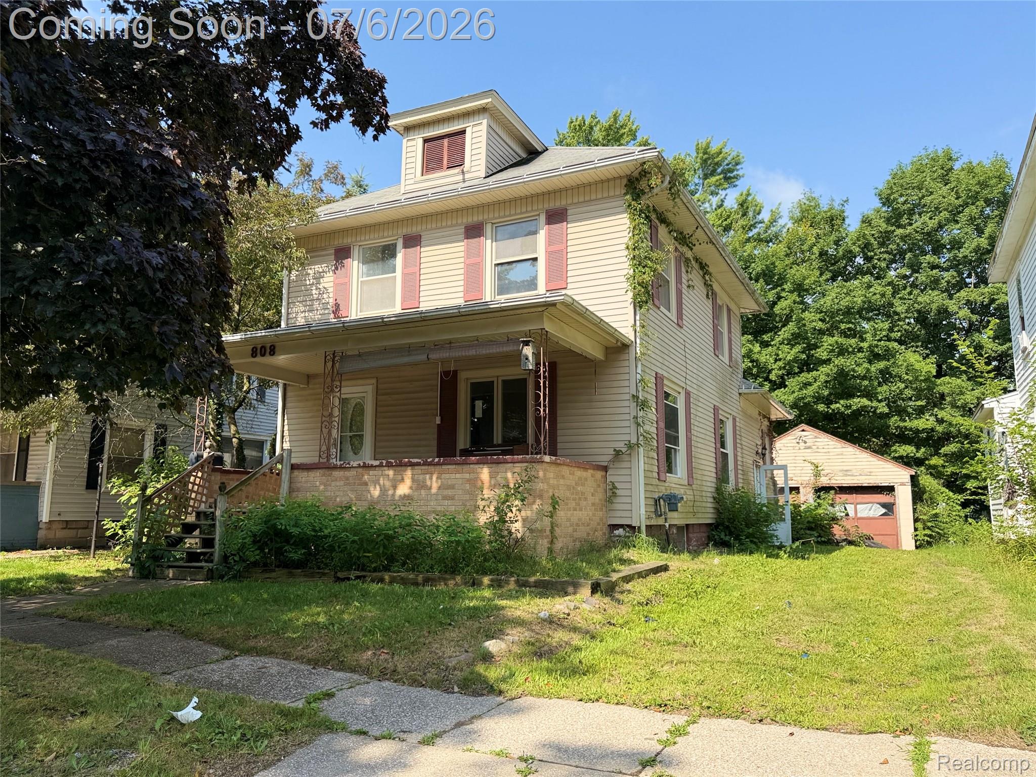 808 Division Street Owosso, MI 48867 - Photo 1 of 25 Two-story residential structure with light-toned siding and contrasting red shutters