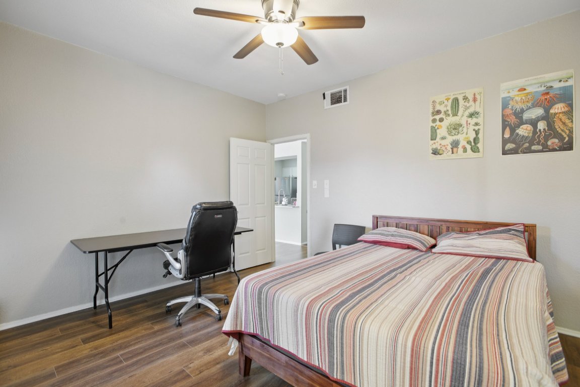 807 West 25th Street, Unit 302 Austin, TX 78705 - Photo 11 of 18 Bedroom featuring dark wood finished floors, ceiling fan, and a desk