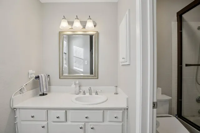 a bathroom with a sink vanity granite and a mirror