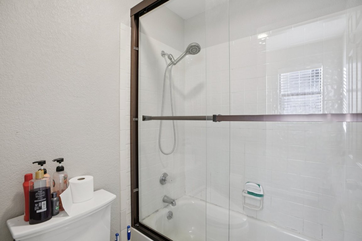 807 West 25th Street, Unit 302 Austin, TX 78705 - Photo 13 of 18 Full bathroom with a textured wall and enclosed tub / shower combo