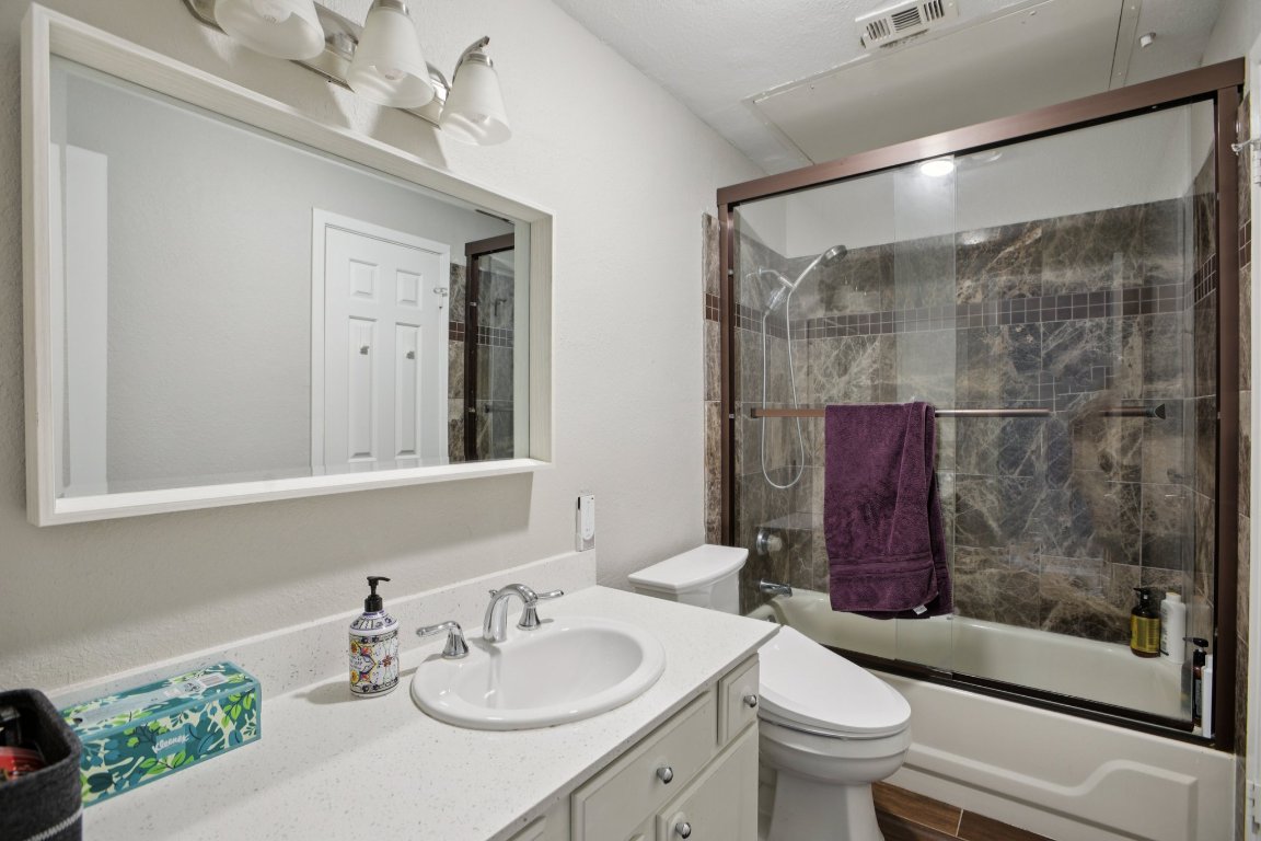807 West 25th Street, Unit 302 Austin, TX 78705 - Photo 14 of 18 Bathroom featuring vanity and shower / bath combination with glass door