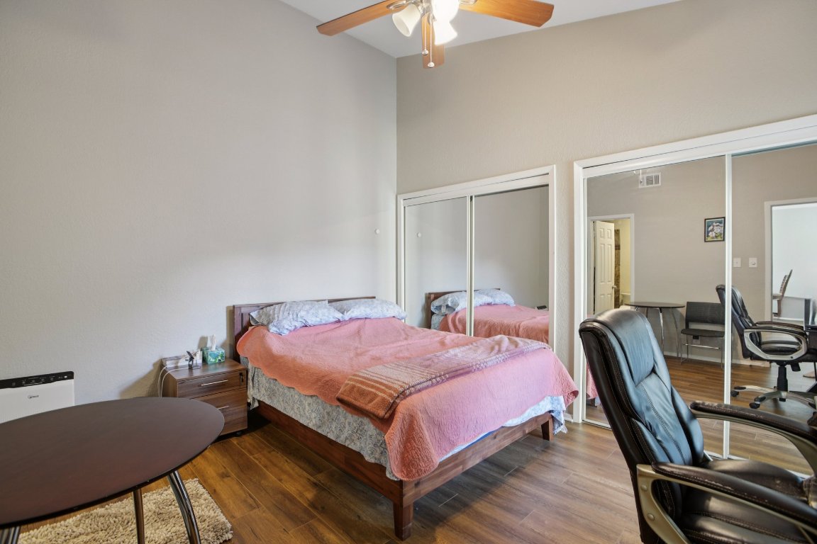 807 West 25th Street, Unit 302 Austin, TX 78705 - Photo 15 of 18 Bedroom with a desk, a towering ceiling, wood finished floors, and ceiling fan