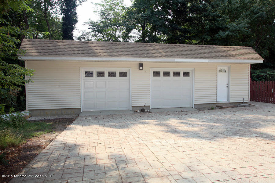 300 Merrick Road Farmingdale, NJ 07727 - Photo 20 of 27 a view of a white house with a small yard and large parking space