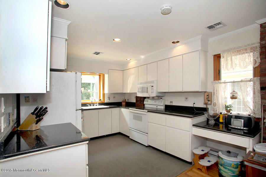300 Merrick Road Farmingdale, NJ 07727 - Photo 3 of 27 a kitchen that has a lot of cabinets a sink and a stove in it