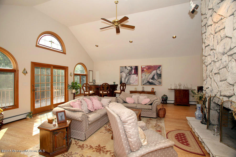 300 Merrick Road Farmingdale, NJ 07727 - Photo 8 of 27 a living room with furniture a fireplace and a floor to ceiling window
