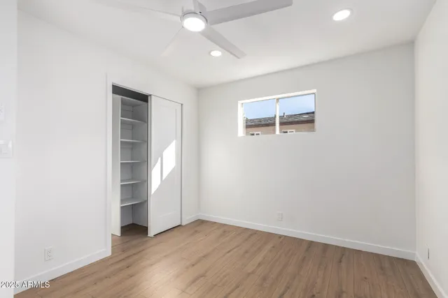 an empty room with wooden floor and window