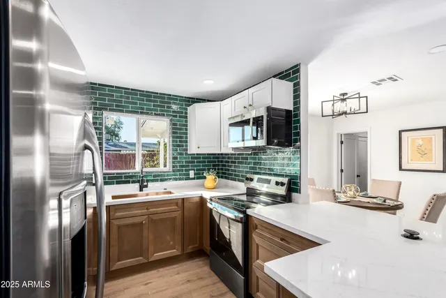 a kitchen with stainless steel appliances granite countertop a sink stove and refrigerator