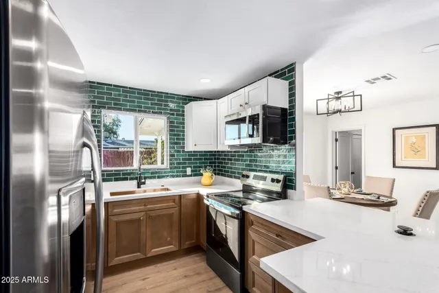 a kitchen with stainless steel appliances granite countertop a sink stove and refrigerator