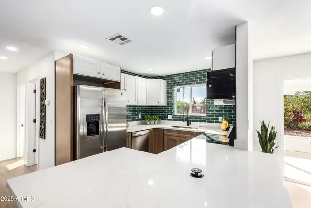 a kitchen with stainless steel appliances a refrigerator sink and stove