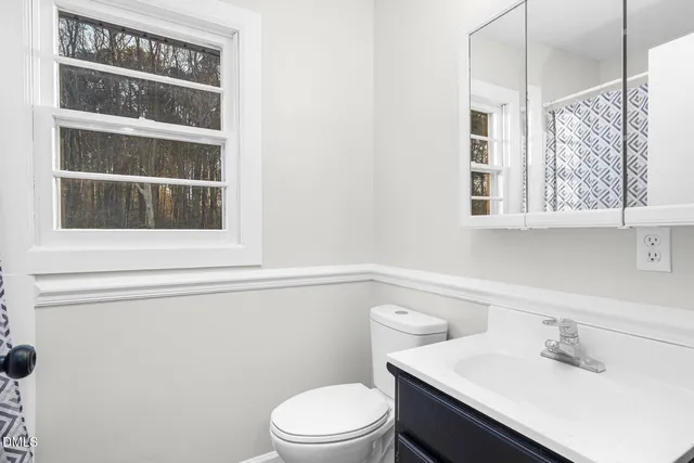 a bathroom with a sink a toilet and a window