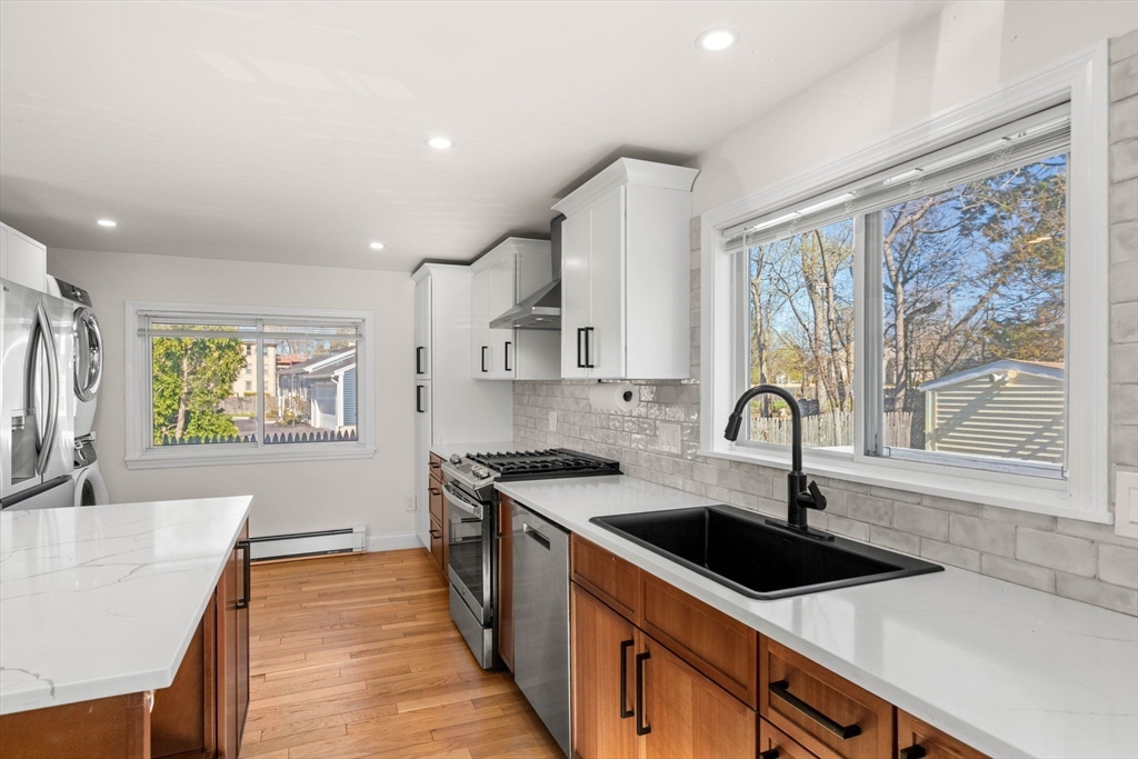 271 Broadway Haverhill, MA 01832 - Photo 13 of 41 a kitchen with a sink a stove a refrigerator cabinets and a window