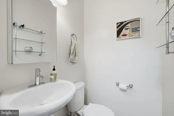 a bathroom with a toilet a sink and mirror