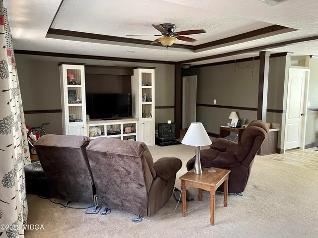 a living room with furniture a flat screen tv and a window