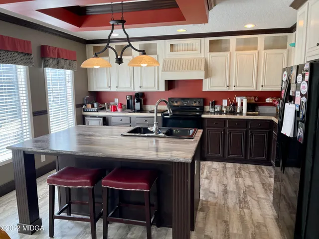 a kitchen with stainless steel appliances kitchen island granite countertop a table chairs in it and wooden floors