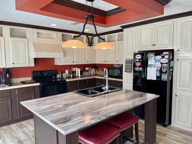 a kitchen with stainless steel appliances granite countertop a sink a stove and refrigerator