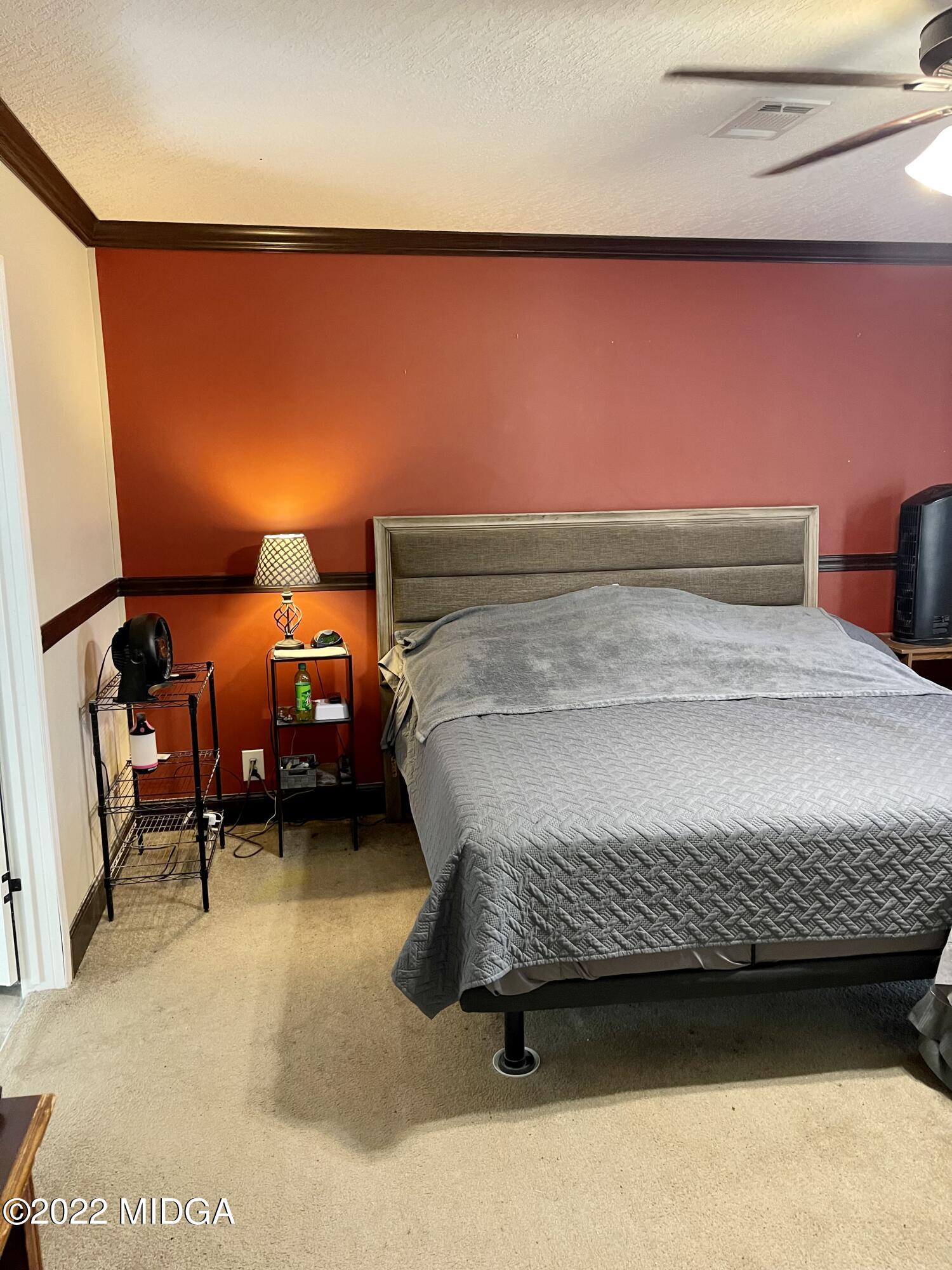 9532 Old Gordon Road Dry Branch, GA 31020 - Photo 9 of 29 a bedroom with a bed chair and wall painting