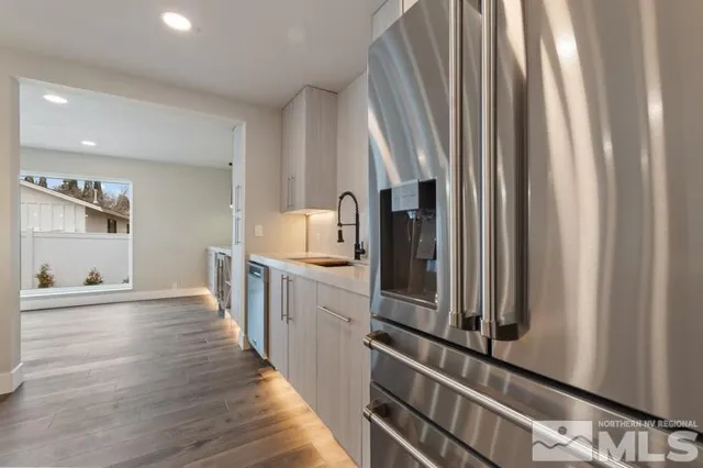 a kitchen with sink a refrigerator and trees