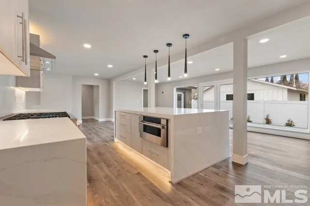 a kitchen with stainless steel appliances kitchen island granite countertop a refrigerator a stove and a sink