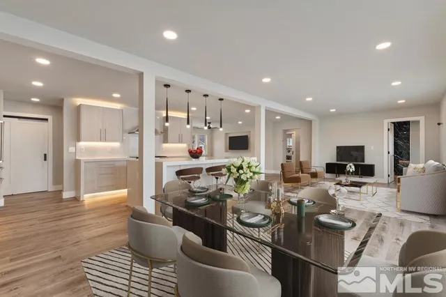 a living room with furniture a flat screen tv and kitchen view