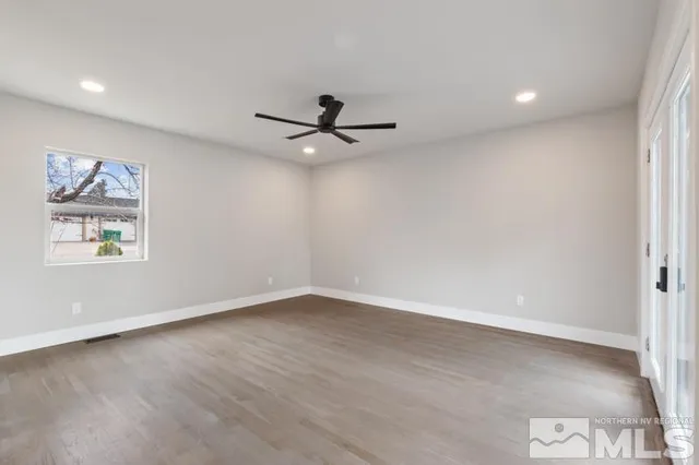 an empty room with a window and a ceiling fan