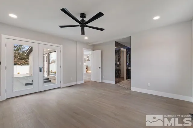 a view of a livingroom with a ceiling fan window and wooden floor