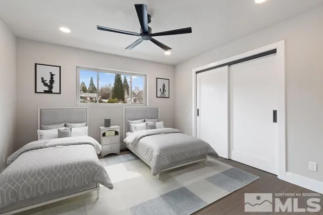 a bedroom with two beds and a ceiling fan