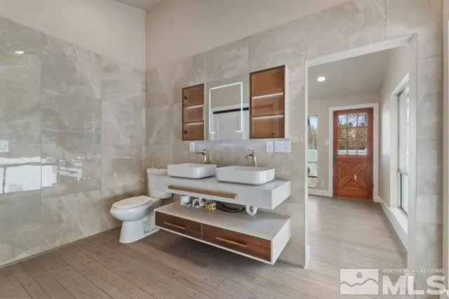 a bathroom with a sink toilet a mirror and shower