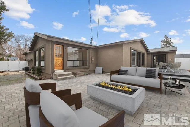 a living room with furniture a chandelier and a dining table