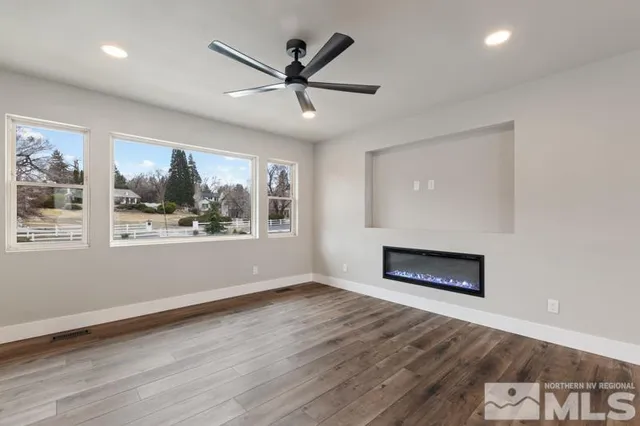 a view of wooden floor fire place refrigerator and window in a room