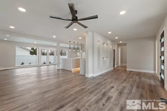 a view of a livingroom with a ceiling fan window a ceiling fan and wooden floor