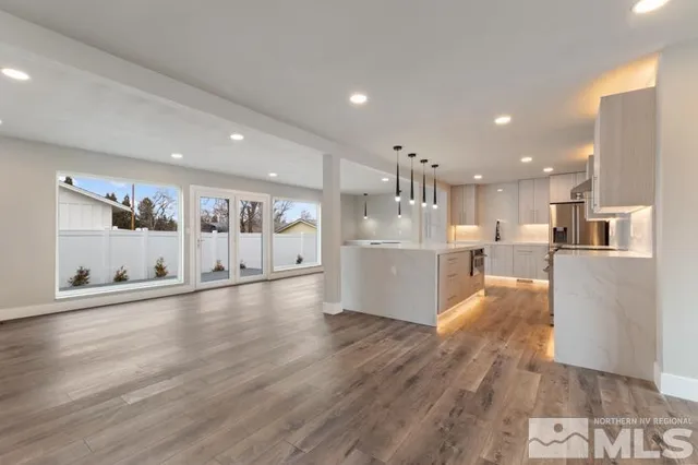 a view of a living room and kitchen with stainless steel appliances