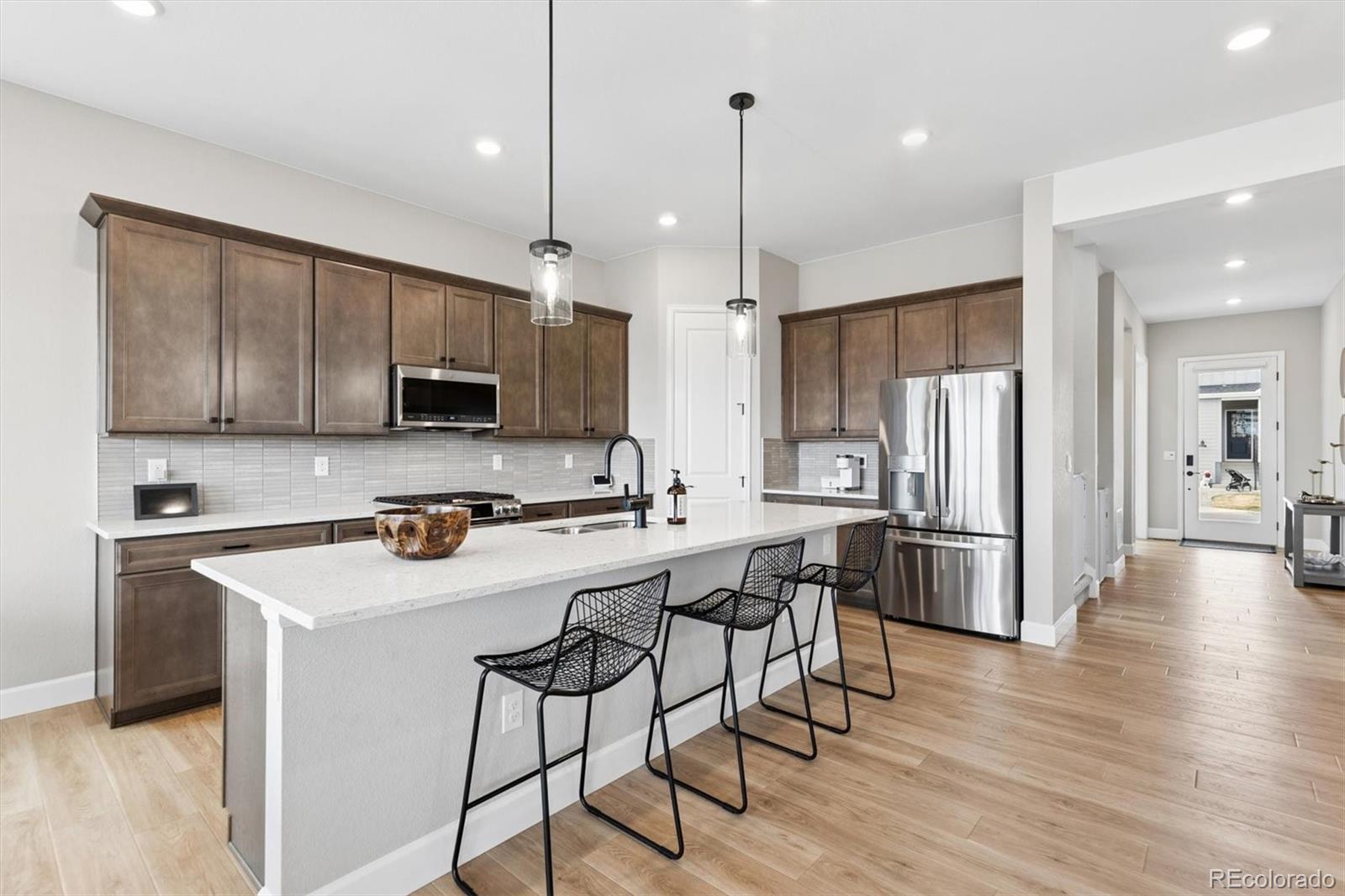 5980 South Platte Canyon Road Littleton, CO 80123 - Photo 13 of 50 a kitchen with stainless steel appliances a stove a sink a refrigerator cabinets and wooden floor