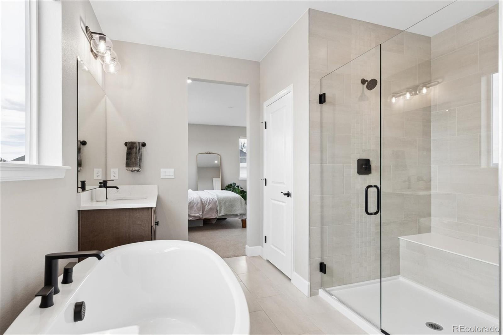 5980 South Platte Canyon Road Littleton, CO 80123 - Photo 29 of 50 a en suite bathroom with a tub shower and mirror