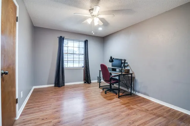 a view of a workspace with furniture and a window