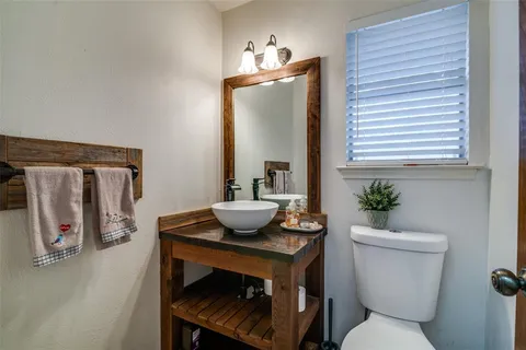a bathroom with a sink a toilet and a mirror