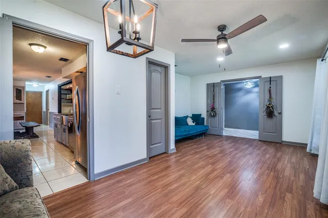 a view of a livingroom with wooden floor and a ceiling fan